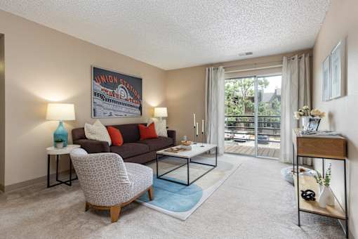 a living room with a couch and a table   and a balcony