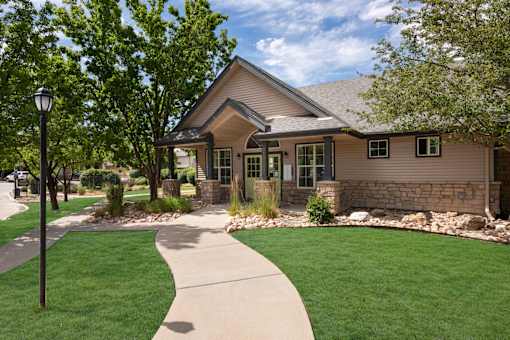 the front of a house with a sidewalk and lawn