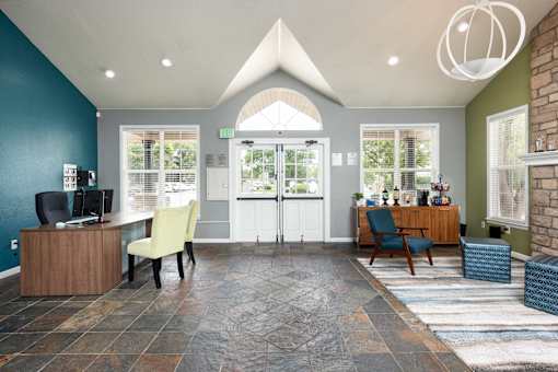 a reception area with a desk and chairs and a glass door