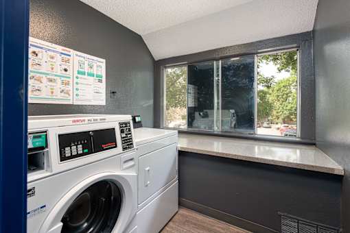 a laundry room with a washing machine and a window