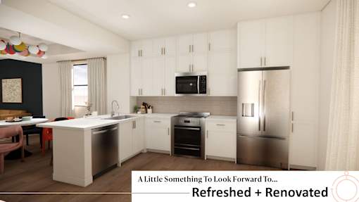 A kitchen with white cabinets and a black countertop.