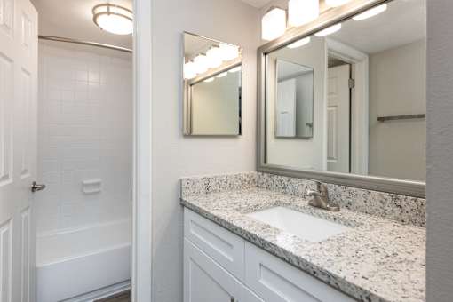 A bathroom with a white tub and sink.