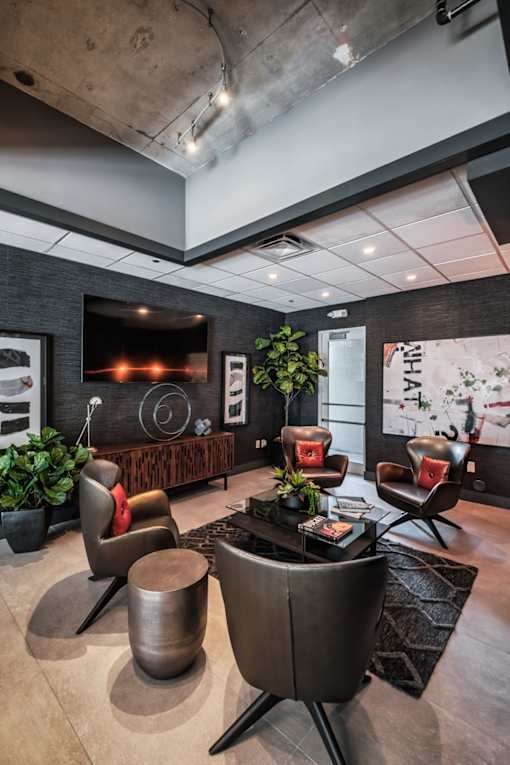 a lobby with chairs and a table and a television