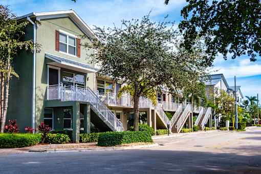 a row of apartment buildings with stairs and trees