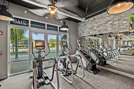 a gym with cardio machines and a view of the pool