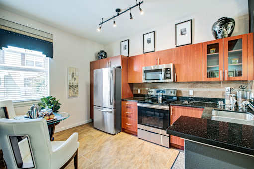 a kitchen with wooden cabinets and stainless steel appliances and a table and chairs