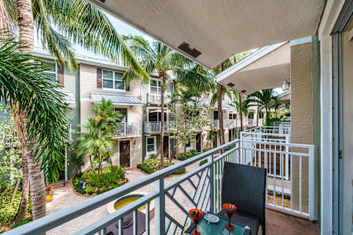 a balcony with a patio and palm trees