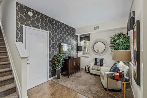 a living room with a white door and a staircase
