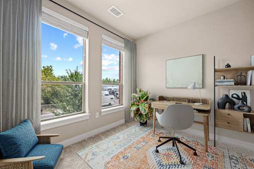 A room with a blue chair and a rug with a pattern on it.