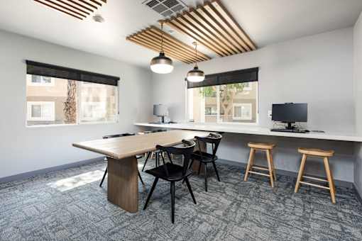 a conference room with a table and chairs and a desktop computer