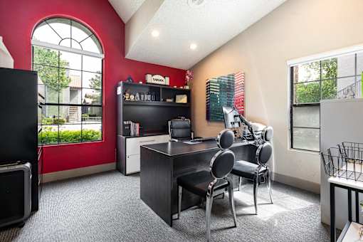 a home office with a desk and chairs and a large window