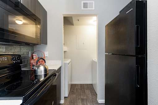 a kitchen with stainless steel appliances and a black refrigerator