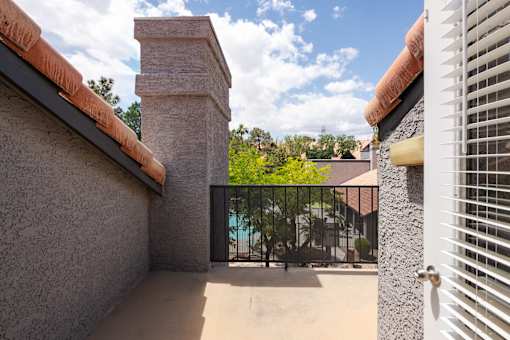 a balcony with a view of a pool and a gate