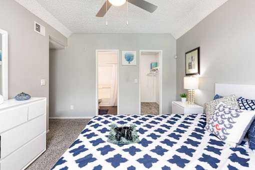 a blue and white bedroom with a bed and a ceiling fan