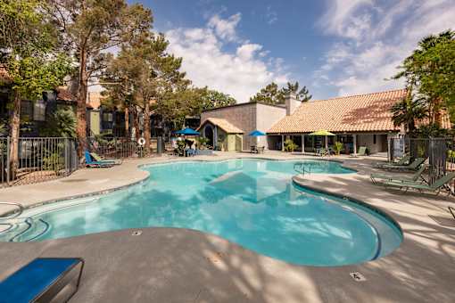 a large swimming pool with a house in the background