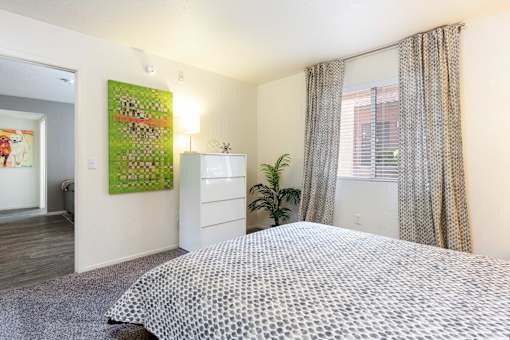 a bedroom with a bed and a window and a dresser