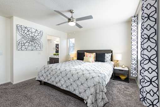 a bedroom with a bed and a ceiling fan