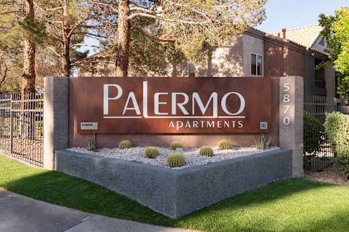 a sign for palermo apartments in front of a fence