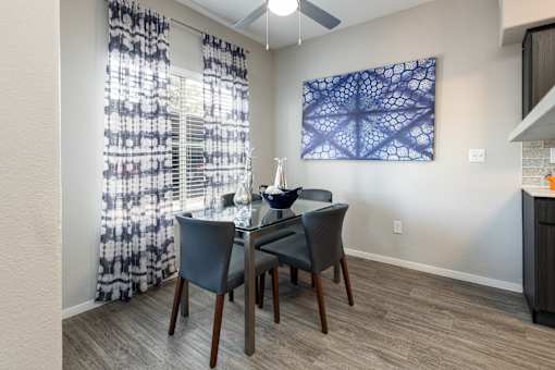a dining room with a table and chairs and a window