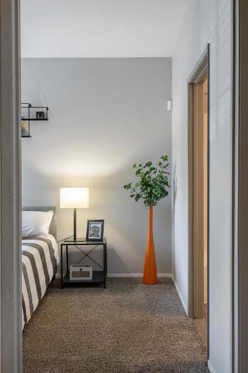 a bedroom with a bed and a vase with a plant