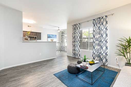 a living room with a table and a kitchen