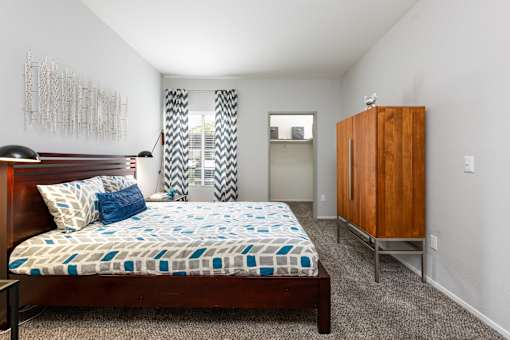 a bedroom with a bed and a dresser and a window