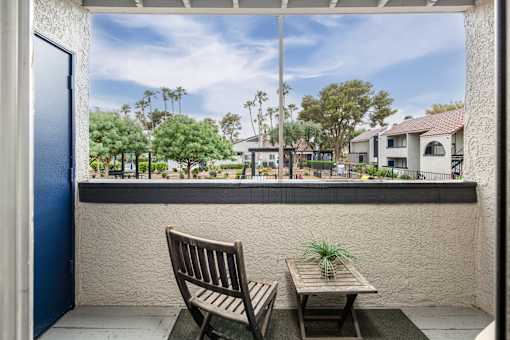 A picture of a patio with a chair and table