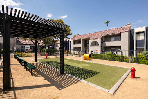 a picnic area with a red fire hydrant and green grass