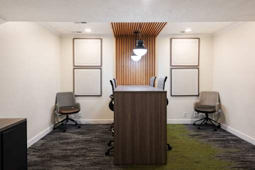 a conference room with a wooden desk and chairs