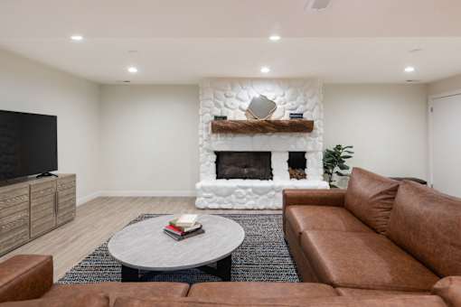 a living room with a couch and a coffee table and a fireplace
