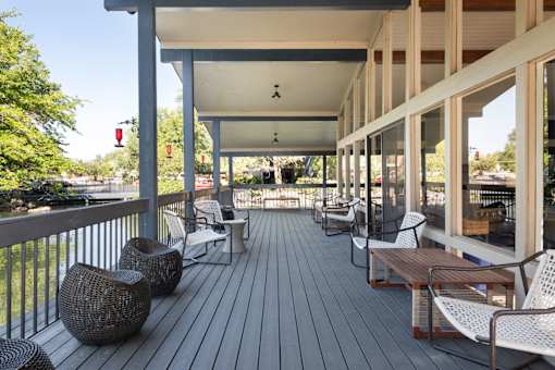 a covered porch with chairs and tables on it