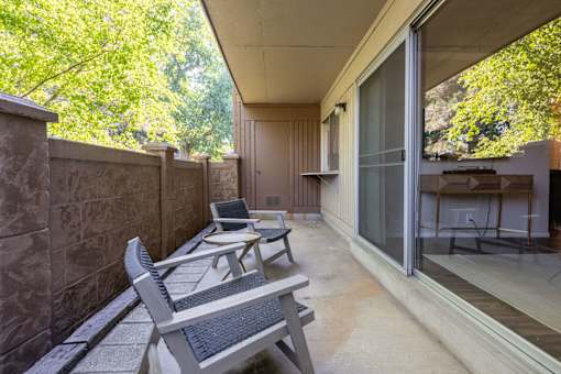 a patio with two chairs and a table on a balcony