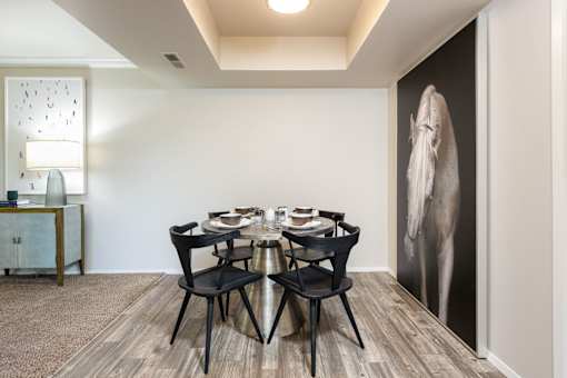 a dining room with a table and chairs and a large wall mural of an elephant