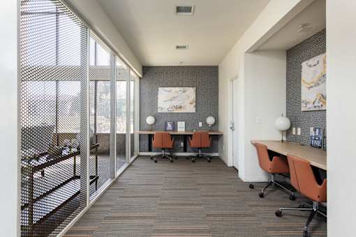 a conference room with a desk and chairs and a window