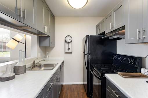 a kitchen with black appliances and white counter tops