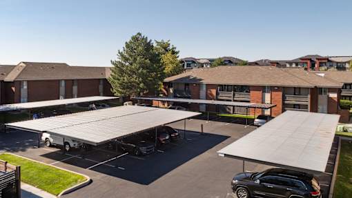 a roofed parking lot in front of a building