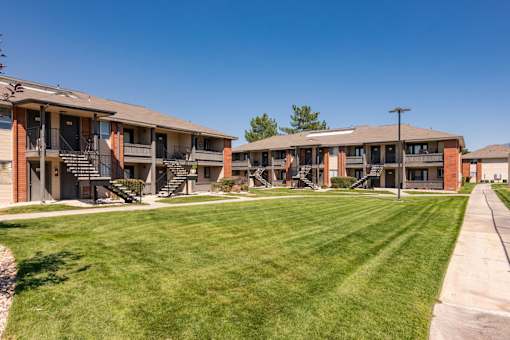 a row of apartments with balconies and a lawn