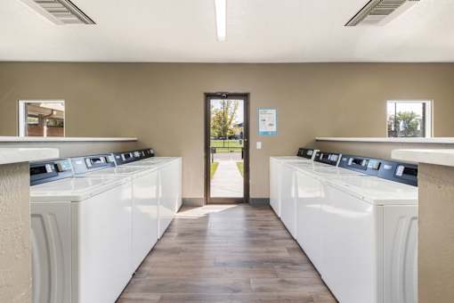 a row of washers and dryers in a laundry room