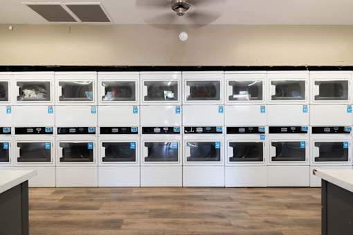 the laundry room is full of white cabinets and appliances