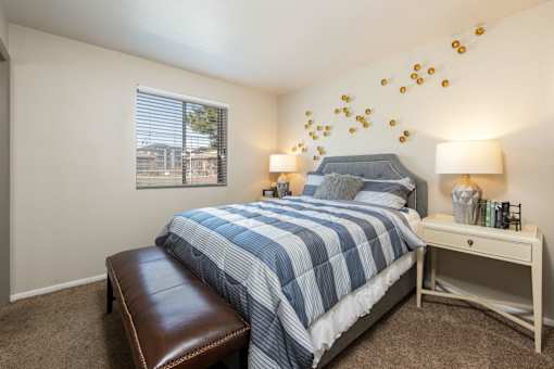 a bedroom with a blue and white bed and a window
