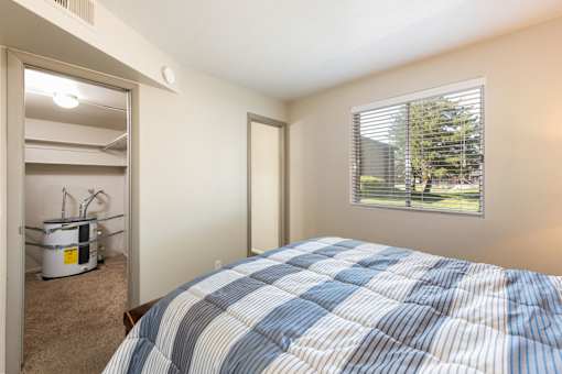 a bedroom with a bed and a closet with a window
