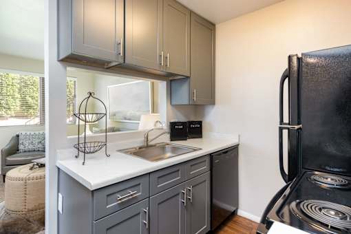 a kitchen with a sink and refrigerator and a window
