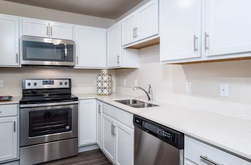a kitchen with stainless steel appliances and white cabinets