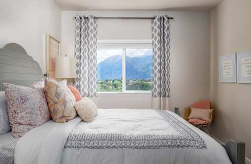 a bedroom with a bed and a window with a mountain view
