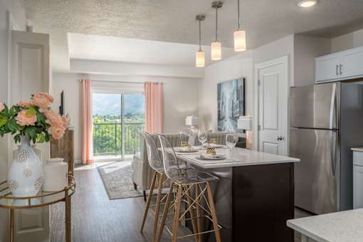 an open kitchen and dining room with stainless steel appliances and a table with chairs