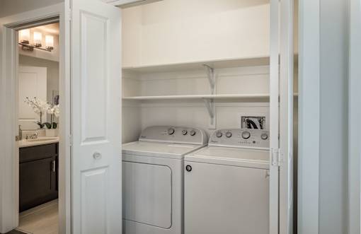 a white washer and dryer in a white laundry room