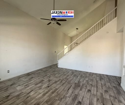 A room with wooden flooring and a staircase.