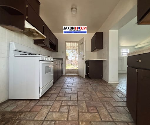 A kitchen with a white oven and brown cabinets.