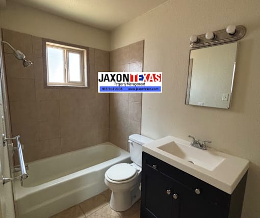 A bathroom with a tub, toilet, sink, and mirror.