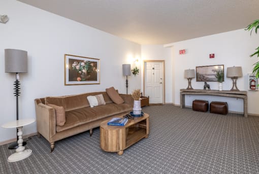 A living room with a brown couch, a coffee table, and a lamp at Eighth Street Manor Apartments, North Dakota, 58103
